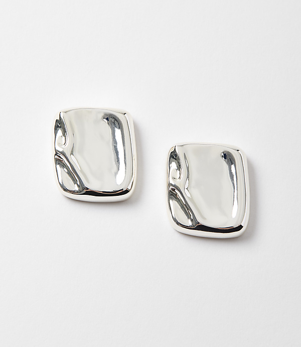 Two abstract, silver square earrings with a molten appearance rest on a plain white background.