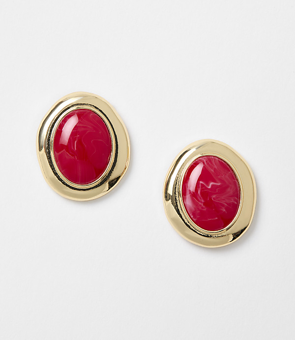 Two gold-rimmed oval earrings with red marbled centers rest on a plain white background.