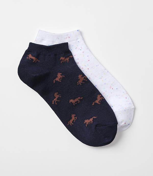 A pair of ankle socks, one navy with a horse pattern and the other white with colorful speckles, rests on a plain white background.