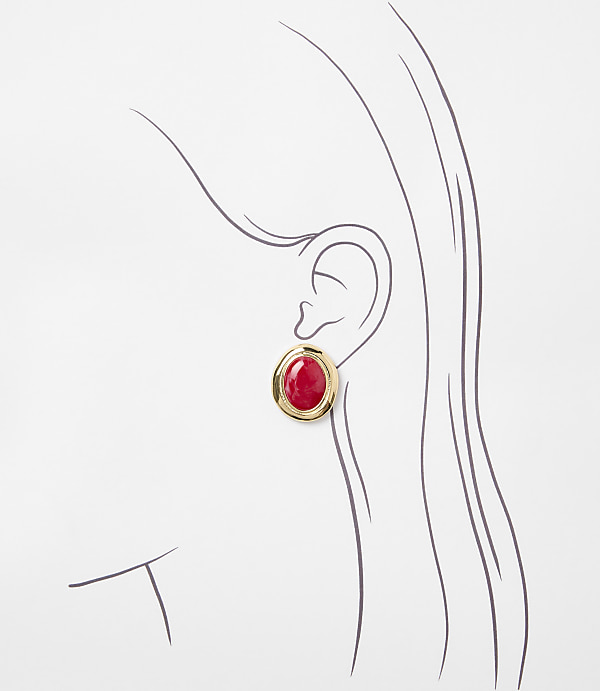 A gold-toned oval earring with a red stone is worn on a sketched ear against a white background.