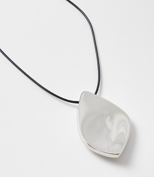 A polished silver pendant with a smooth, teardrop shape hangs from a thin black cord against a plain white background.