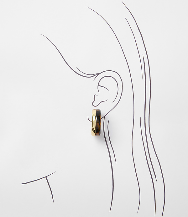 A tortoiseshell and gold hoop earring adorns a stylized ear against a white background.