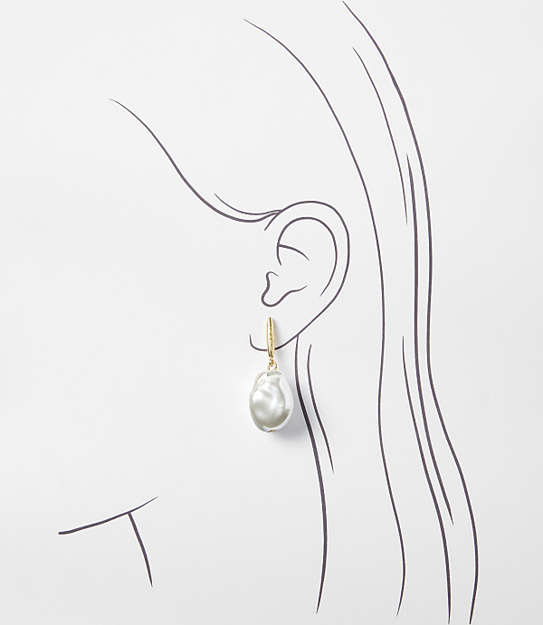 A single baroque pearl earring hangs from a stylized ear against a plain white background.