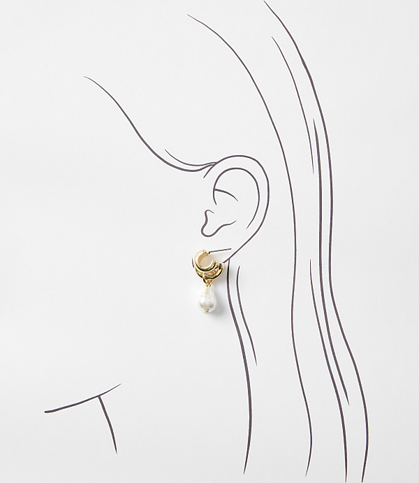 A gold hoop earring with a pearl drop hangs from a stylized ear against a plain white background.
