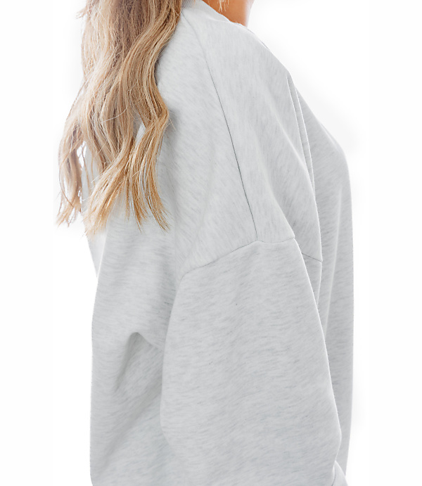 A person's shoulder and blonde hair are visible in the foreground, against a plain white background.