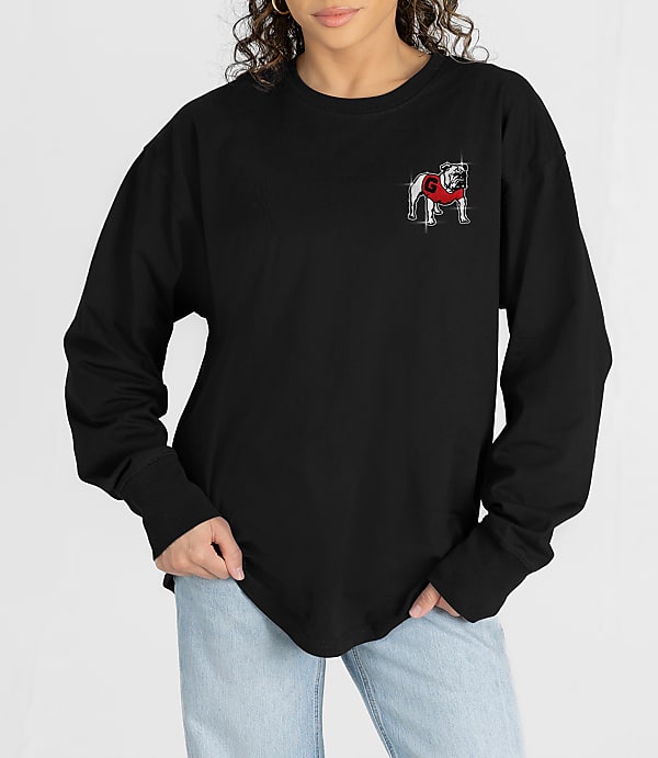 A person in a black long-sleeved shirt with a bulldog graphic on the chest stands against a white background.