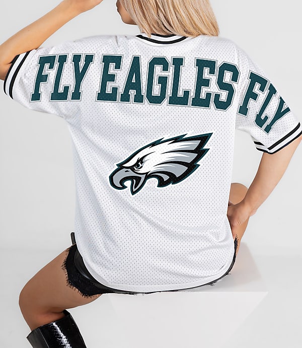 A person in a white "FLY EAGLES FLY" jersey with an eagle logo sits against a plain white background.