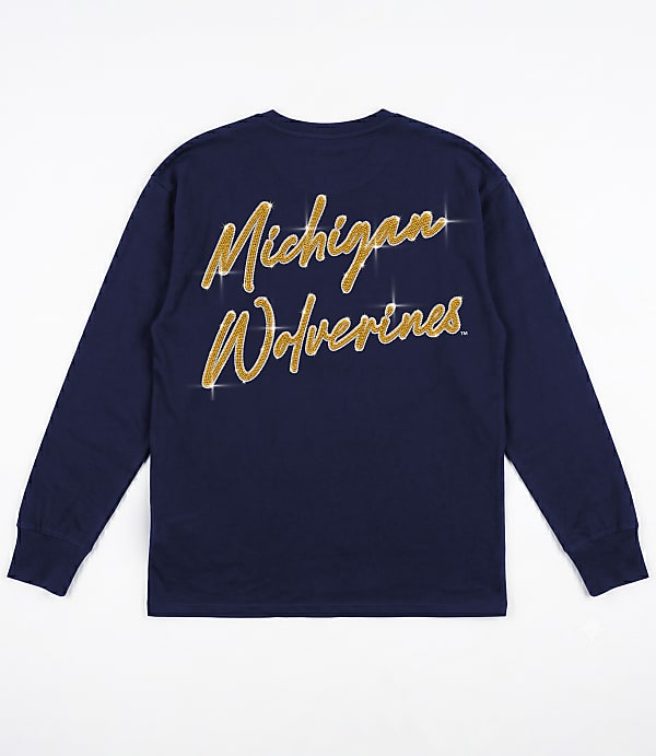 A navy blue long-sleeved shirt with "Michigan Wolverines" written in gold glitter is laid flat against a white background.