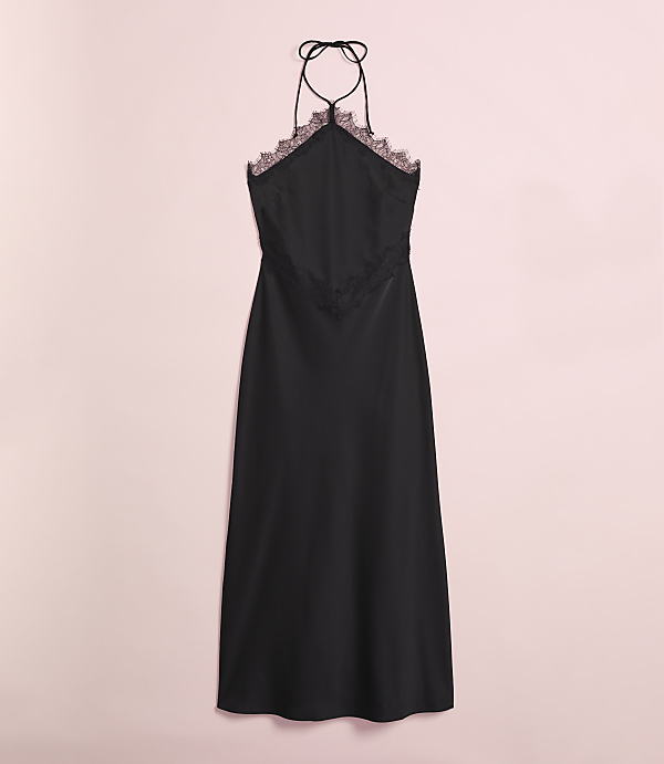 A black satin slip dress with lace trim hangs against a soft pink background.