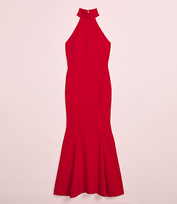 A vibrant red, floor-length halter dress with a flared hemline is presented against a soft pink background.