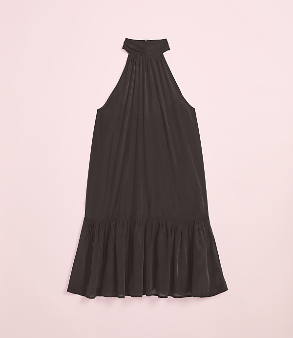 A dark, flowing halter dress with a ruffled hem rests on a soft pink background.