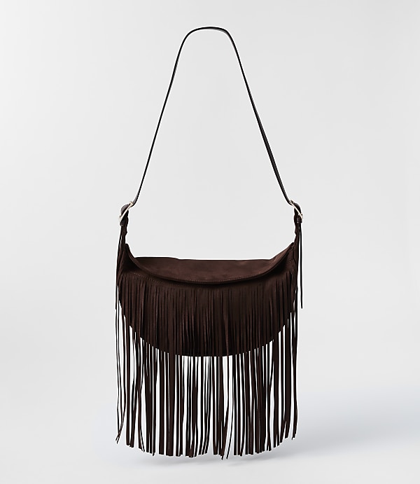 A dark brown suede fringe bag with a single strap hangs against a plain white background.