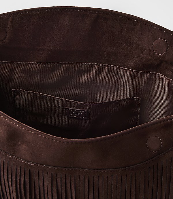 A brown suede fringed clutch with a satin lining and a small logo tag is presented against a plain white background.