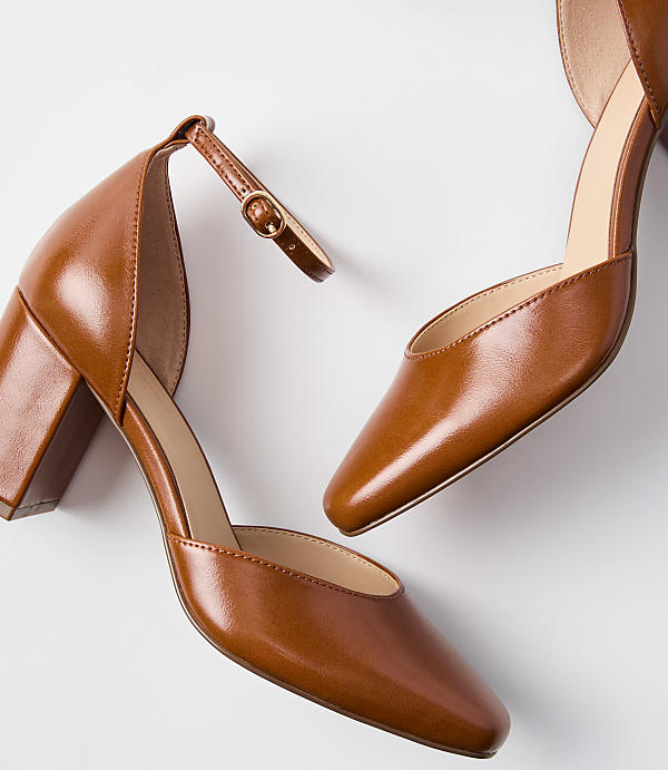 Two brown leather block heels with ankle straps are arranged on a plain white background.