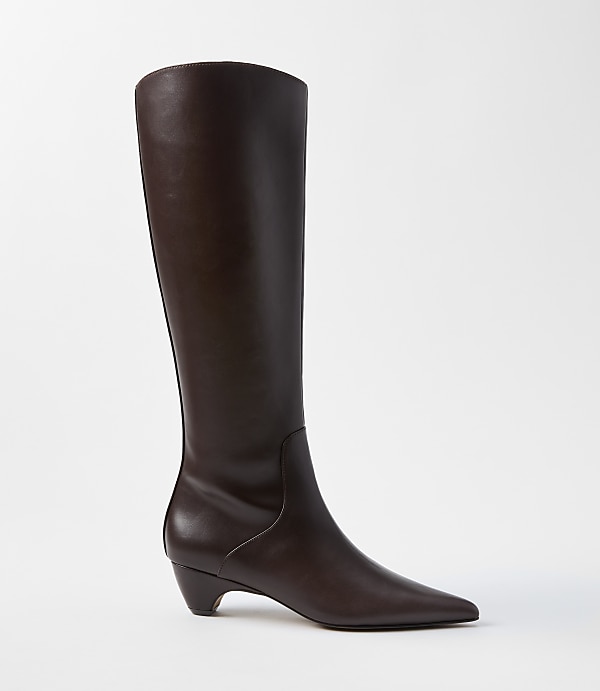 A dark brown leather knee-high boot with a pointed toe and a low heel stands against a plain white background.
