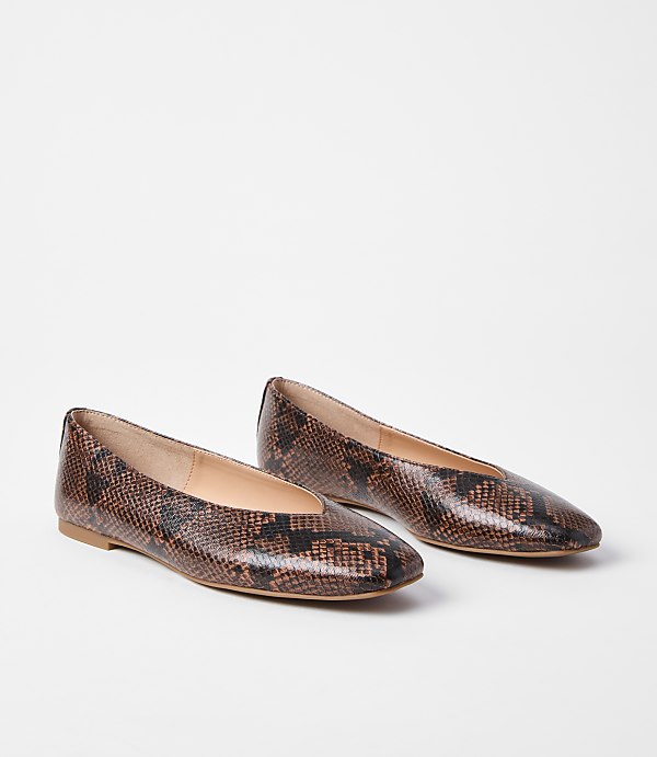 A pair of brown snakeskin ballet flats rests on a plain white background.