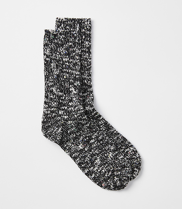 A pair of speckled black and white socks rests on a plain white background.