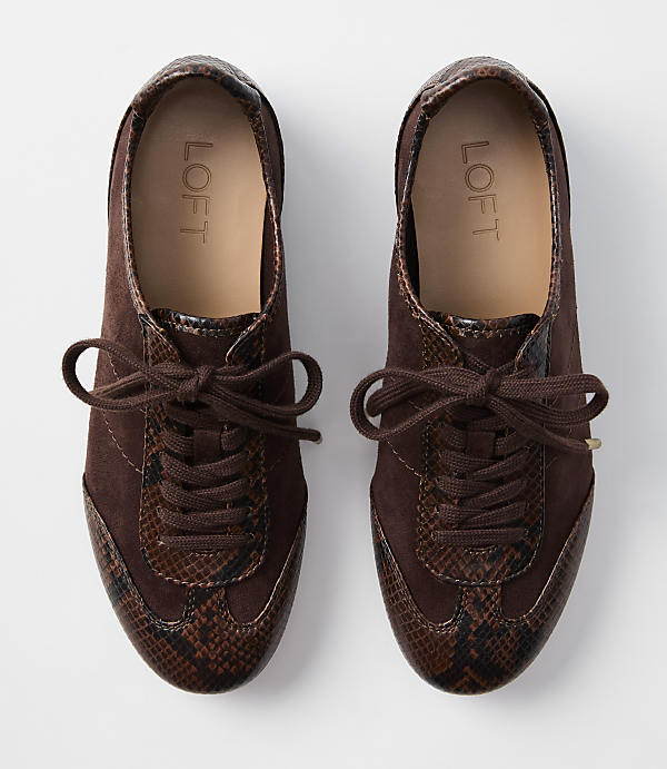A pair of brown suede and snakeskin sneakers with laces are laid out on a white background.
