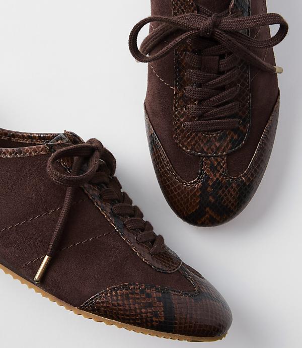 Two brown suede sneakers with snakeskin accents are displayed against a plain white background.
