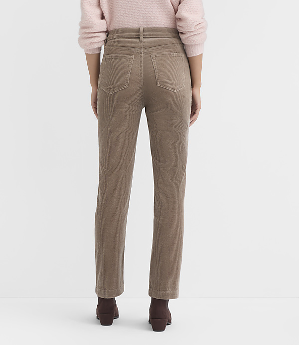 A person wearing tan corduroy pants and brown boots stands against a plain white background.
