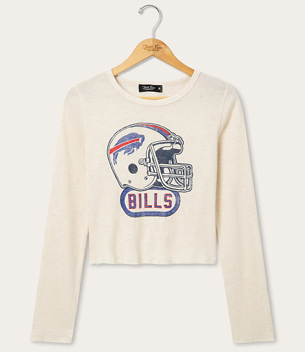 A cream-colored long-sleeved shirt with a vintage Buffalo Bills helmet graphic is displayed on a wooden hanger against a white background.