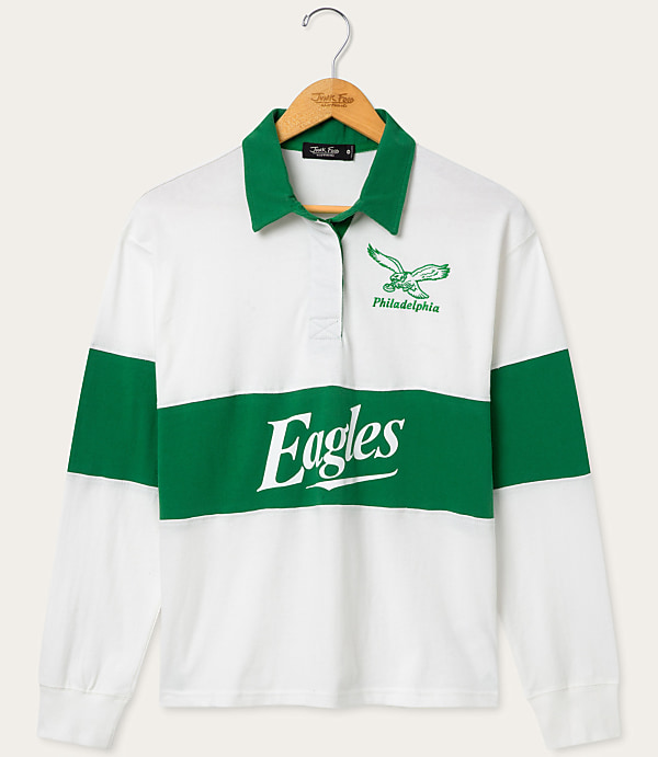 A white and green Philadelphia Eagles rugby shirt hangs on a wooden hanger against a plain white background.