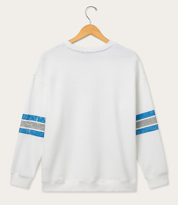 A white sweatshirt with blue and gray stripes on the sleeves hangs on a wooden hanger against a plain white background.