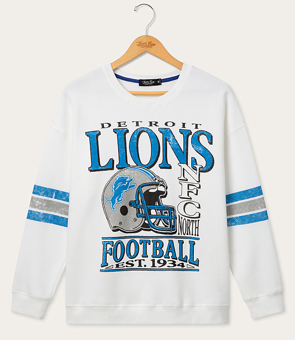 A white Detroit Lions sweatshirt with blue and silver stripes on the sleeves hangs on a wooden hanger against a plain light background.