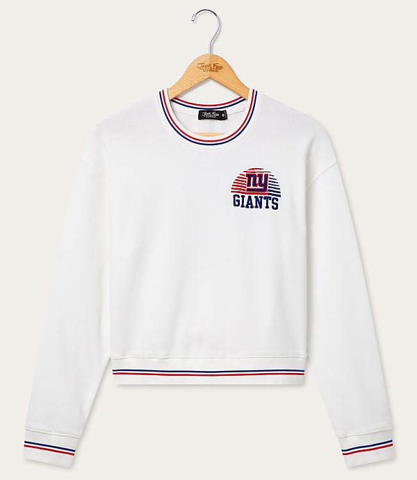 A white New York Giants sweatshirt with striped trim hangs on a wooden hanger against a plain white background.