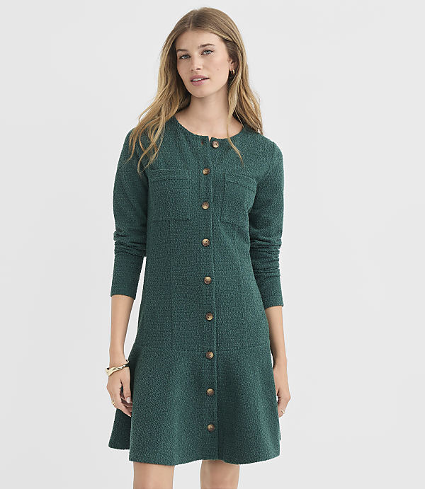 A woman in a green textured dress stands against a plain white background.