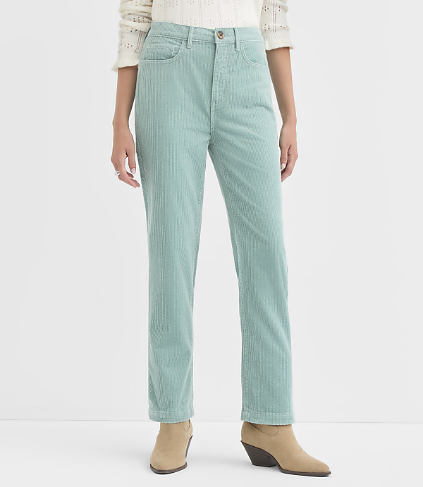 A person stands in the foreground wearing light blue corduroy pants and tan ankle boots, against a plain white background.