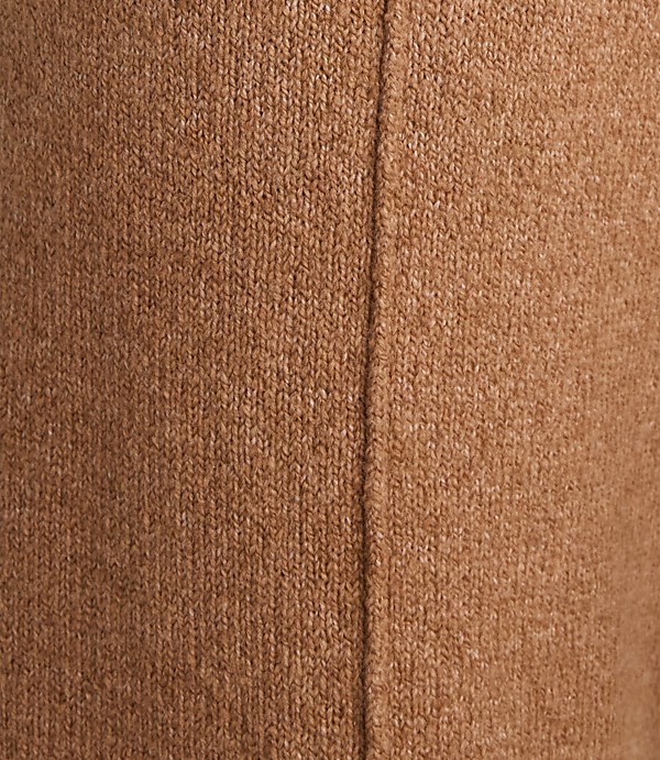 A close-up of brown knitted fabric with a seam running vertically down the center.