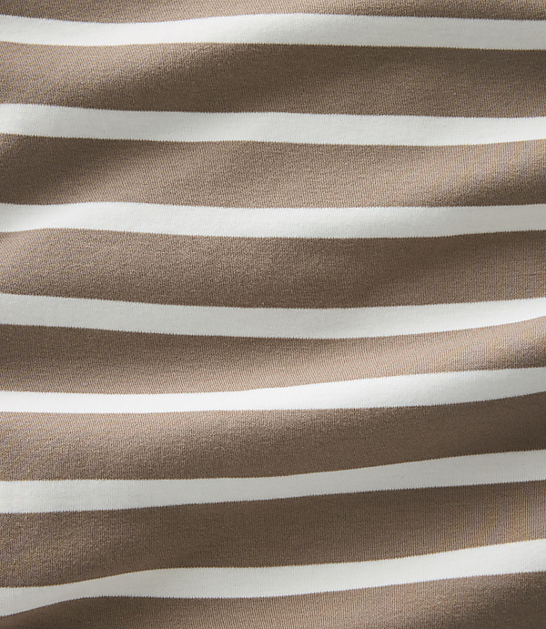 A close-up view of brown and white horizontal stripes on fabric fills the frame, with subtle wrinkles creating a textured background.
