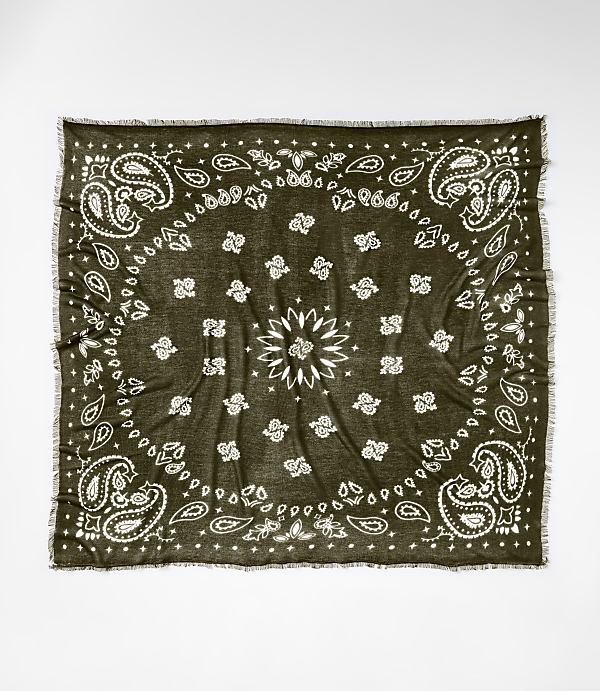 A dark green bandana with a white paisley pattern and frayed edges lies flat against a plain white background.