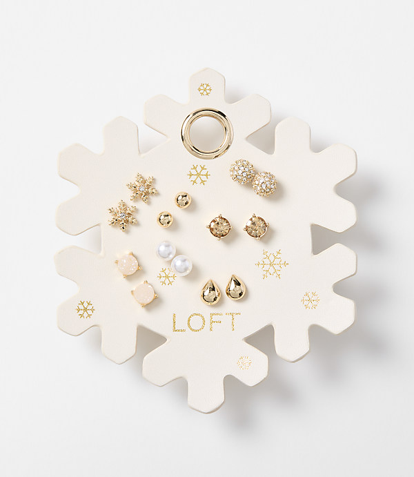 A snowflake-shaped card displays an assortment of small, decorative earrings in the foreground, set against a plain white background.