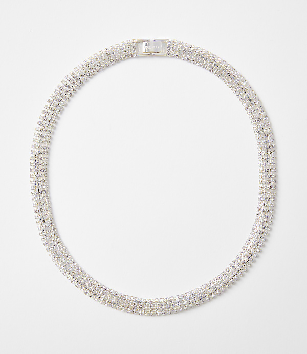 A sparkling, multi-layered rhinestone necklace with a silver clasp rests on a plain white background.