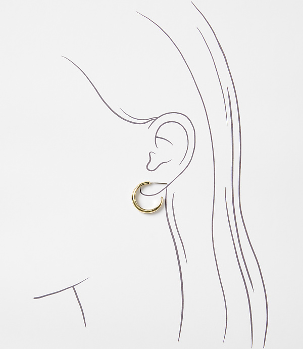 A delicate gold hoop earring adorns a sketched ear against a plain white background.