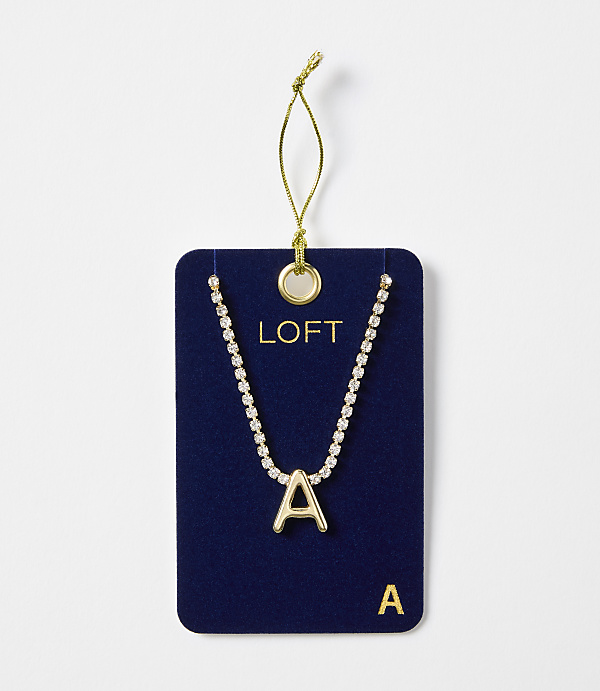 A gold letter "A" necklace with a rhinestone chain is displayed on a dark blue card with the "LOFT" logo, against a plain white background.