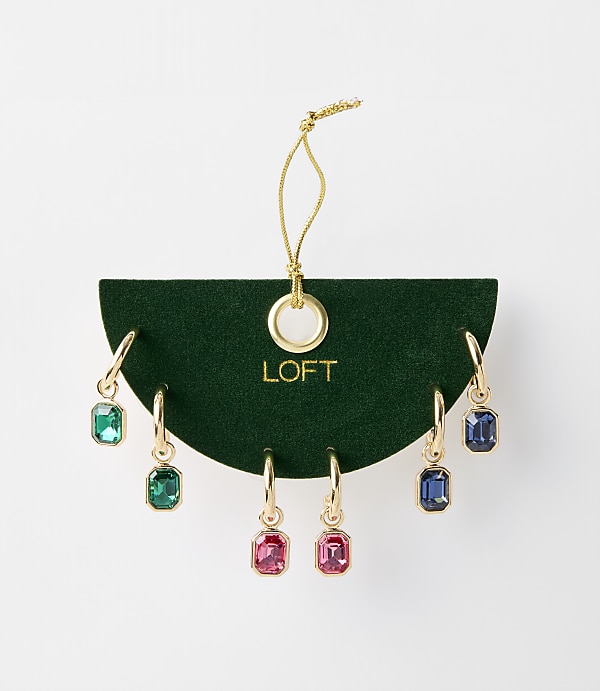 A set of colorful gemstone drop earrings are displayed on a dark green velvet card with the LOFT logo, against a plain white background.