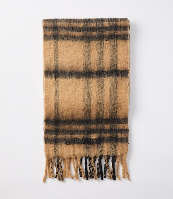 A fuzzy, plaid scarf with fringed ends lies flat against a plain white background.