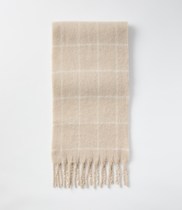 A fuzzy, beige plaid scarf with fringe lies on a plain white background.