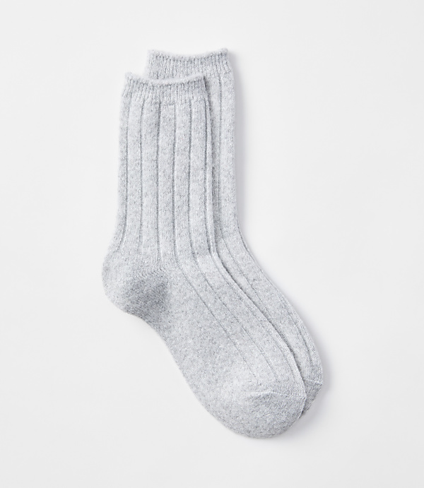 A pair of light gray ribbed socks rests on a plain white background.