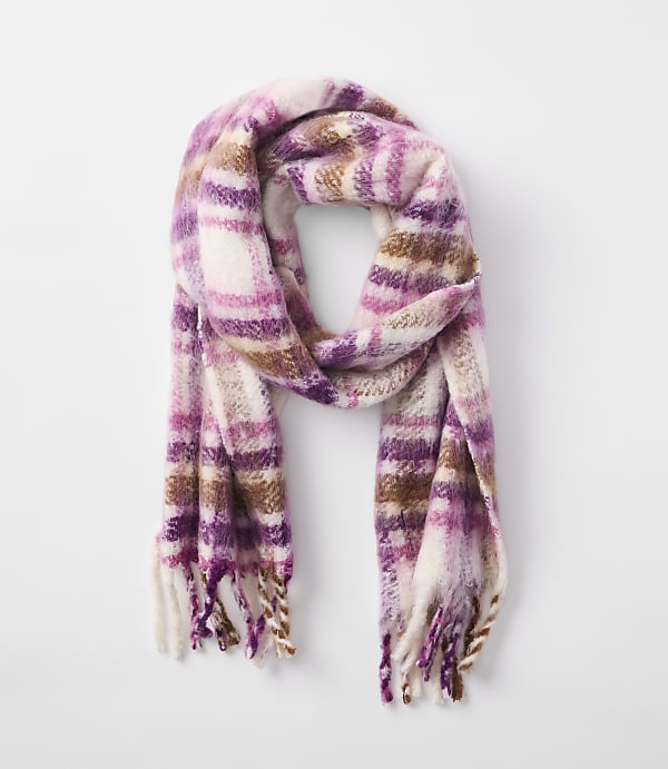 A fuzzy, plaid scarf in shades of pink, purple, and brown hangs against a plain white background.