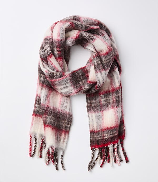 A fluffy, plaid scarf with red, white, and brown colors is laid out against a plain white background.