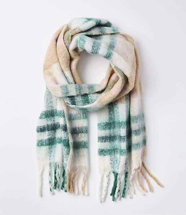 A soft, plaid scarf with fringe in pastel colors is laid out against a plain white background.