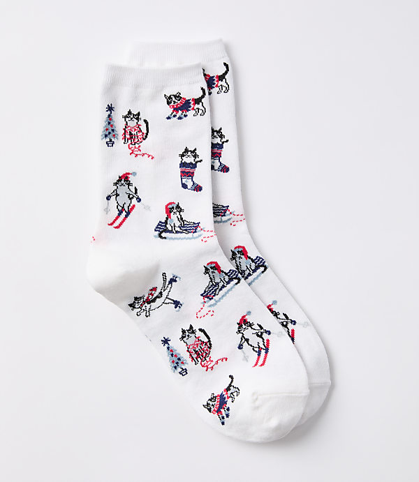 White socks with a pattern of cartoon cats in winter activities are displayed against a plain white background.