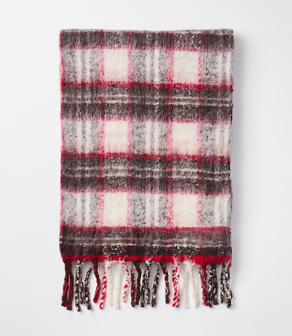 A fuzzy, red, white, and brown plaid scarf with fringe lies on a plain white background.