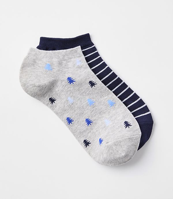A pair of ankle socks, one with a gray background and blue tree pattern, and the other with navy and white stripes, rests on a plain white background.