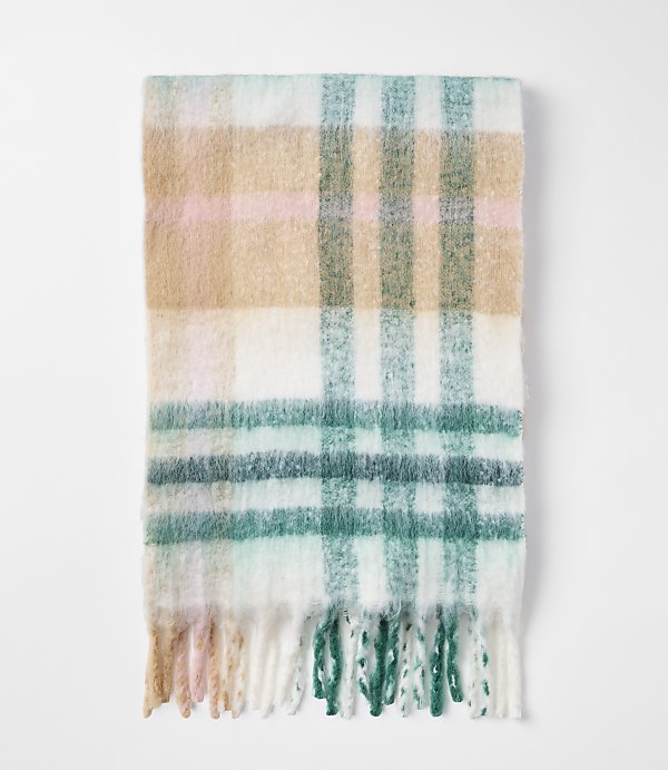 A soft, plaid scarf with fringe in pastel colors lies on a plain white background.