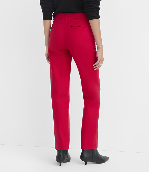 A person wearing red pants and black boots stands against a plain white background.